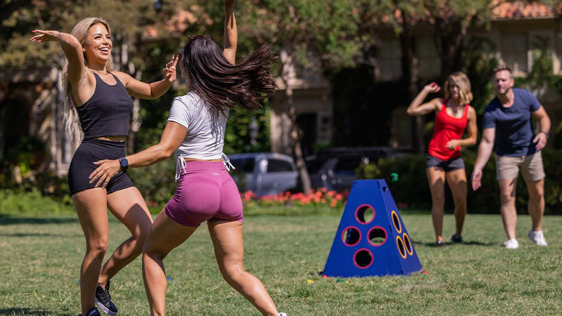 Two Women Celebrating While Playing TowerBall With Family